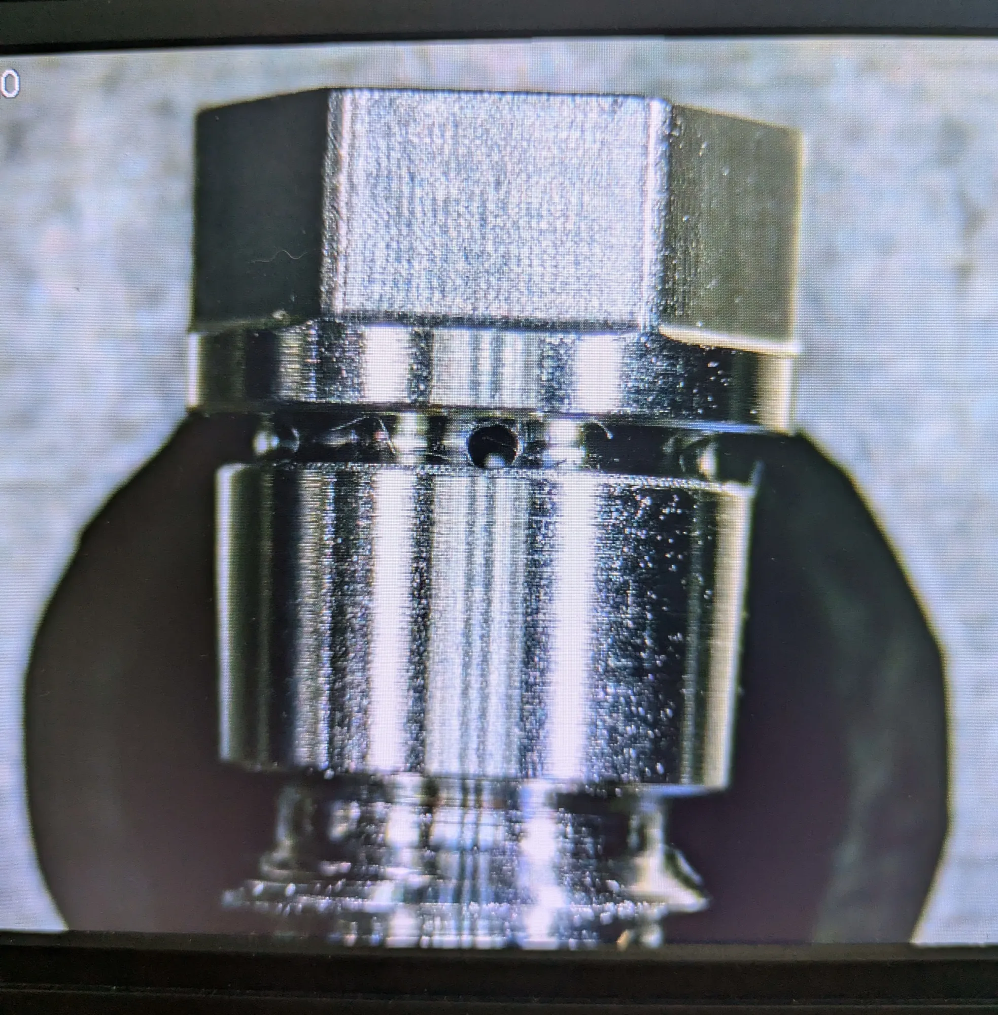 A threaded hex fitting magnified on an optical comparator screen